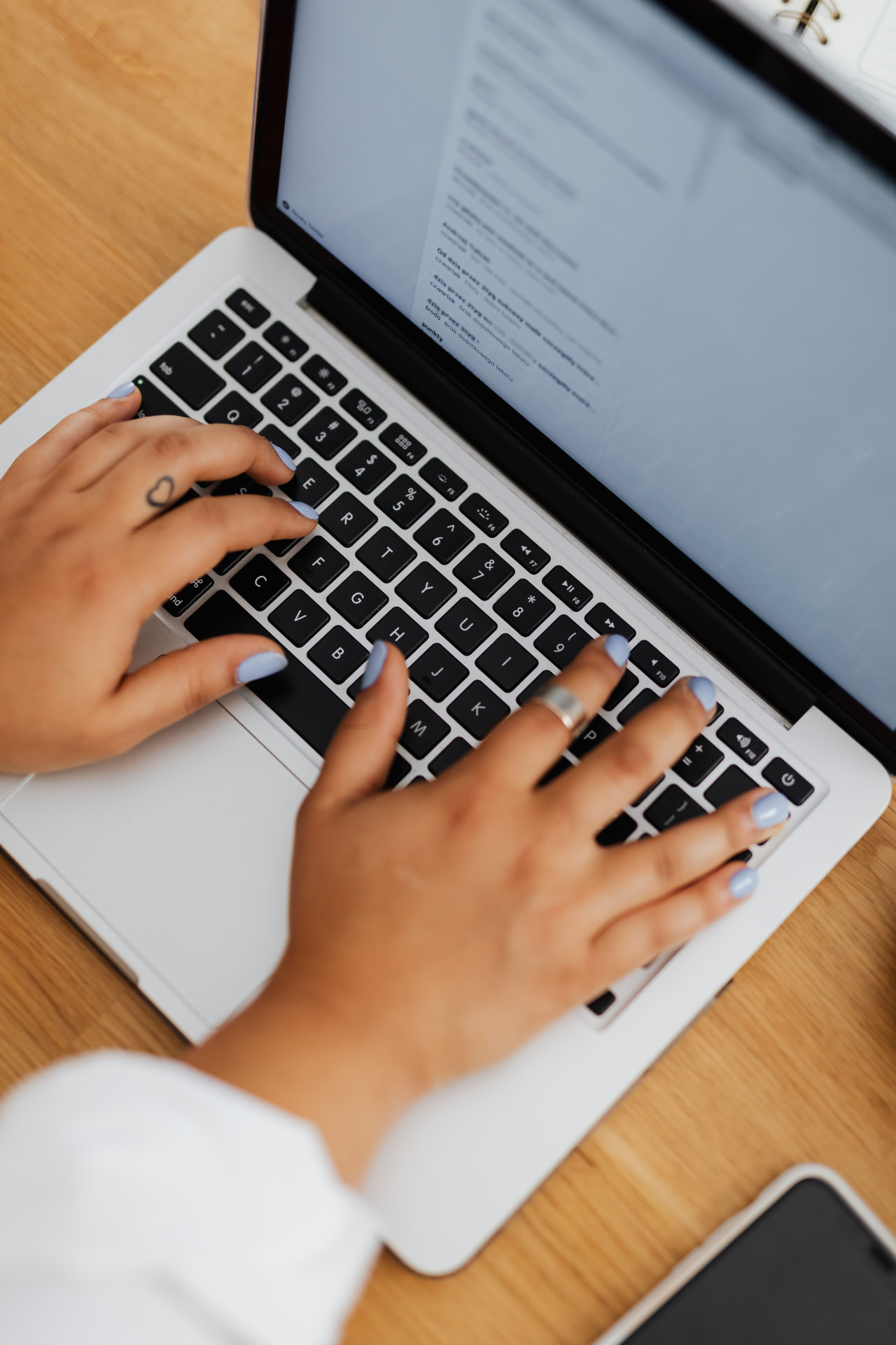 Close-up of hands writing on a laptop keyboard
